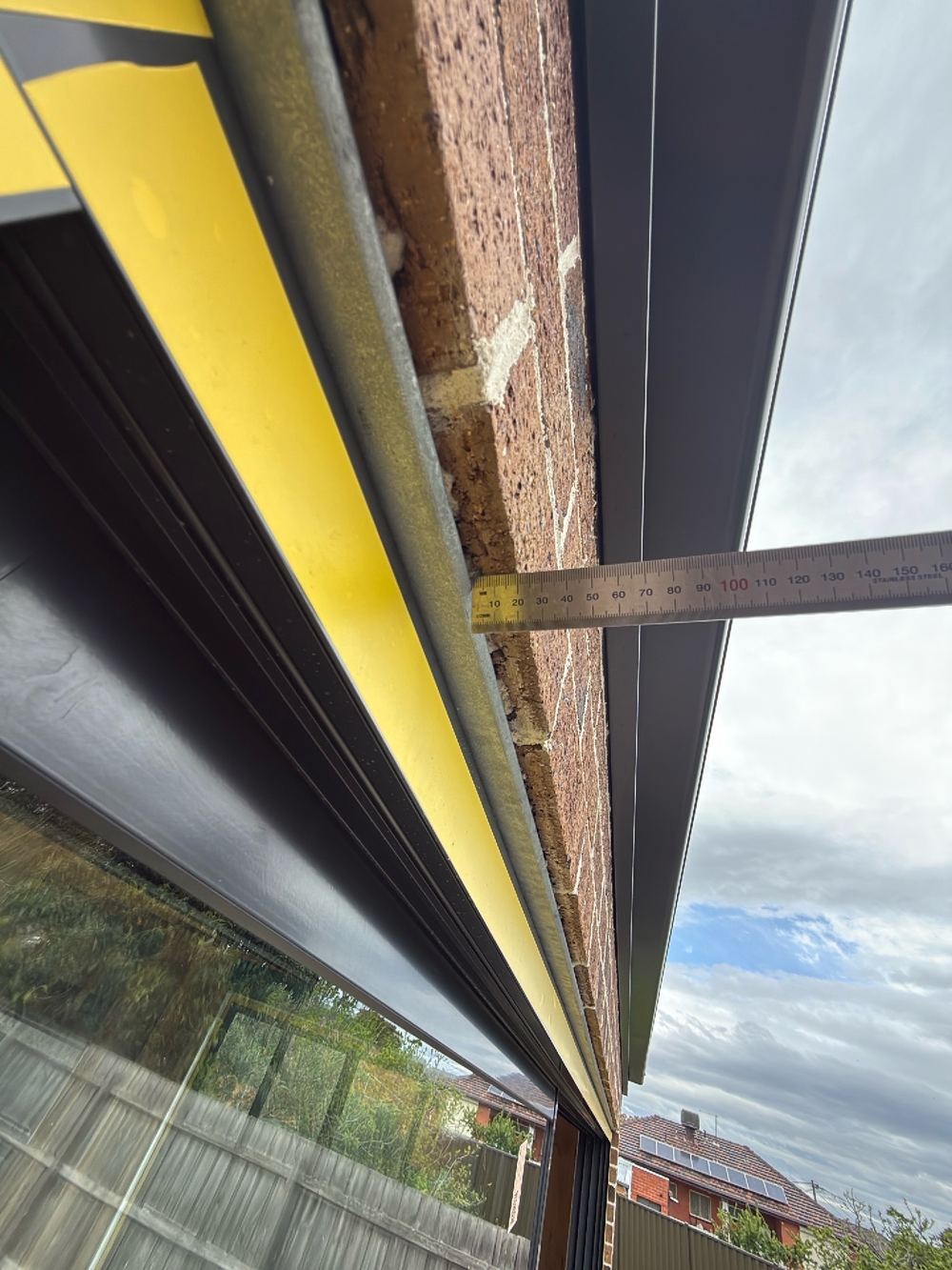Brick overhang above the steel lintels changing from one opening to the next, found during a defect investigation inspection in Reservoir